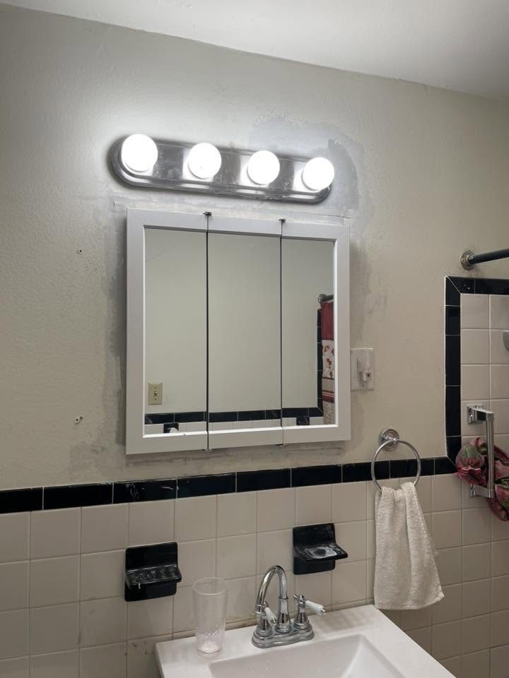 Remodeled bathroom vanity with mirror and lighting